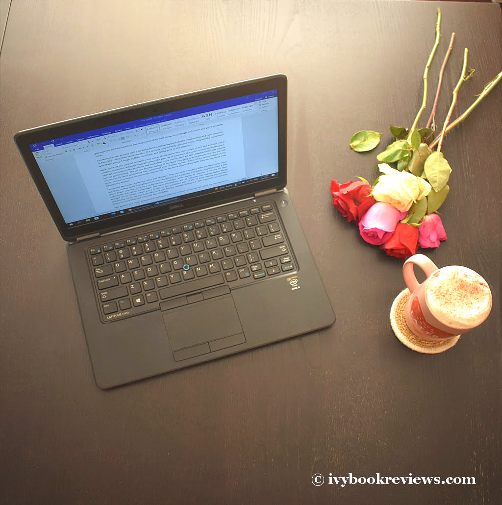 A laptop, flowers and a good latte on a table