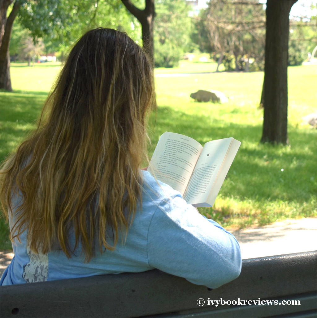 Ivy reading a book on a bench